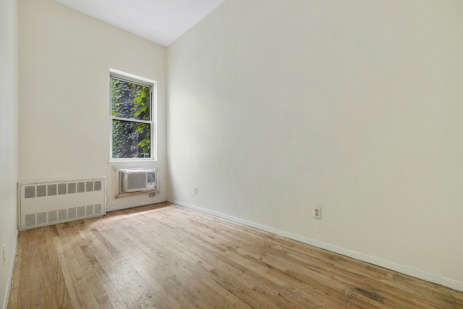 359 West 30th Street, Unit 2B Manhattan, NY 10001 - Photo 14 of 16 an empty room with wooden floor and windows