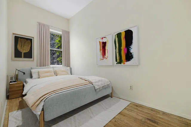 a bedroom with a bed and a painting on the wall