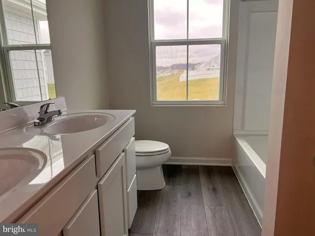 a bathroom with a toilet a sink and a window