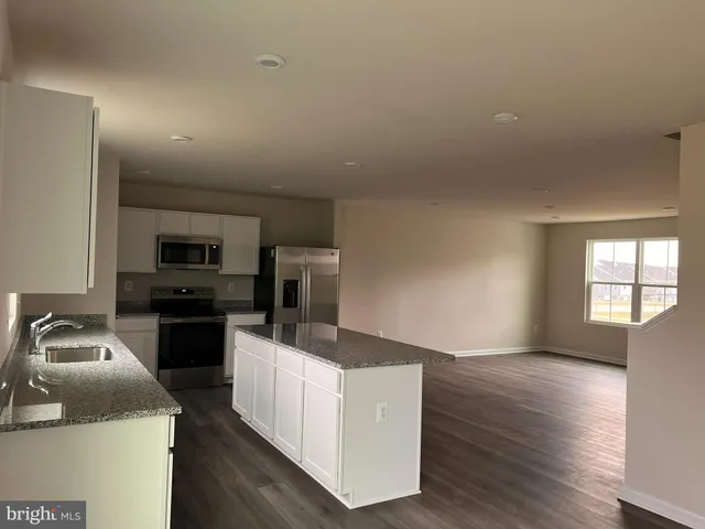 a kitchen with sink refrigerator and microwave