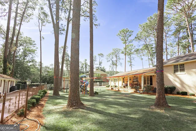 a front view of a house with a big yard and potted plants