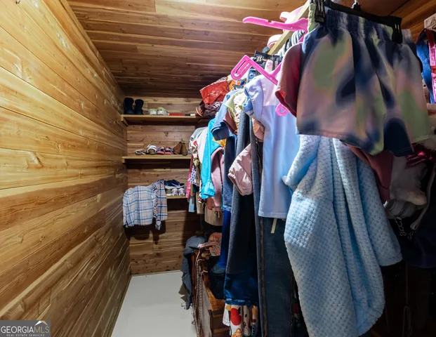 a view of walk in closet with clothes and shoes