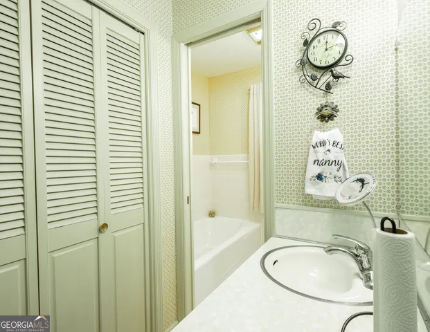 a bathroom with a granite countertop sink a mirror and a shower