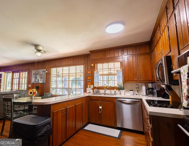 a kitchen with stainless steel appliances a counter space a sink and a window