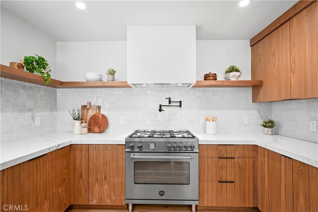 3758 Alzada Road Altadena, CA 91001 - Photo 15 of 59 Chef's kitchen with quartz counter, stainless Bertazzoni range, hood, refrigerator, dishwasher, pot filler, and glazed stone backsplash