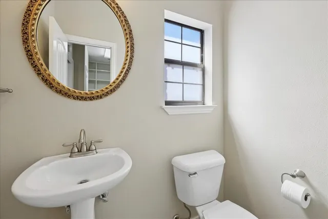 a bathroom with a toilet a sink and a mirror