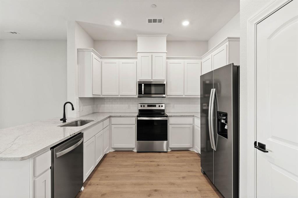 a kitchen with a sink stainless steel appliances and cabinets