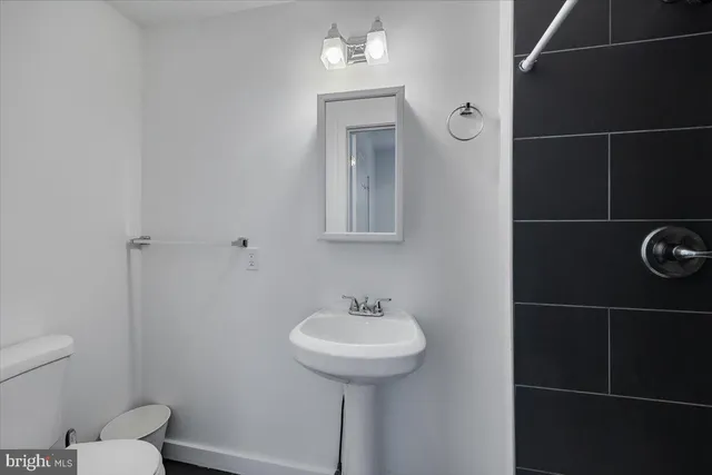 a bathroom with a sink toilet and a mirror