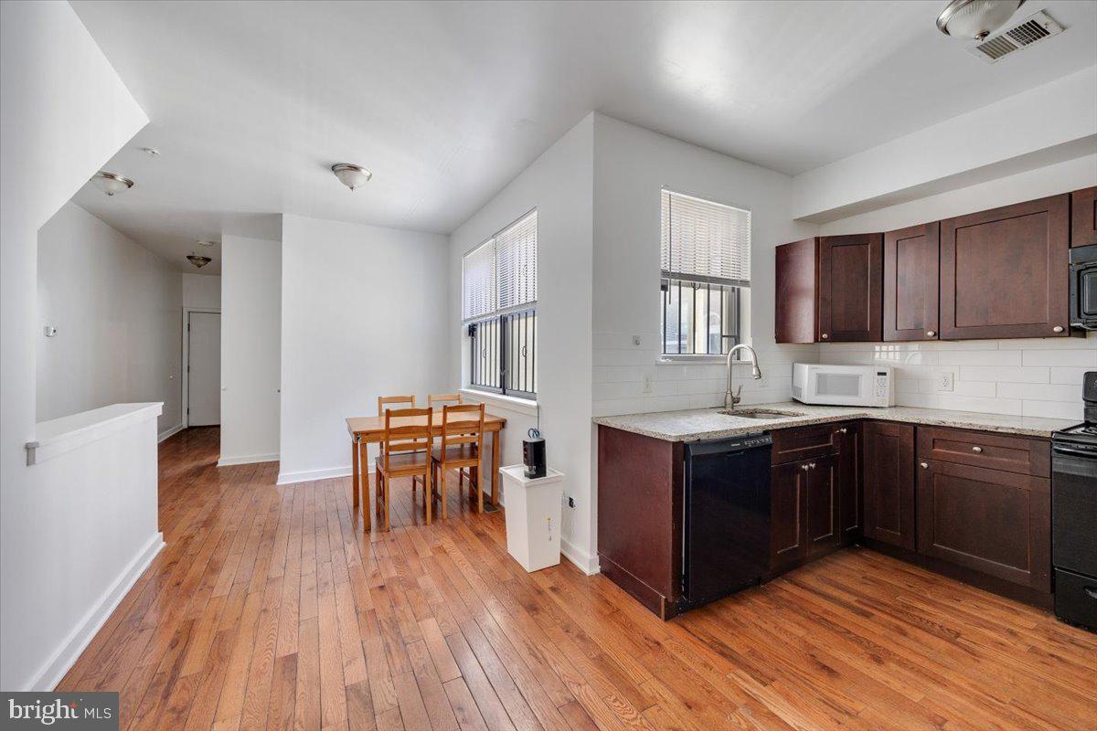 1322 North 15th Street, Unit A Philadelphia, PA 19121 - Photo 4 of 27 a kitchen with wooden floors and wooden cabinets
