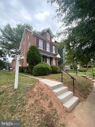 a view of a house with backyard and tree