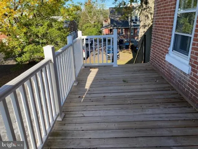 a balcony with wooden floor and outdoor seating