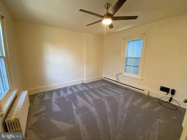 a view of a livingroom with a ceiling fan and window