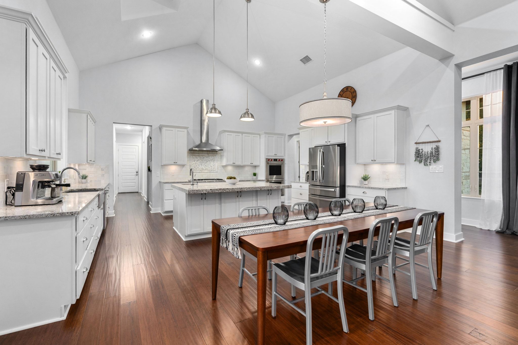 1821 Overland Stage Road Dripping Springs, TX 78620 - Photo 15 of 39 a kitchen with stainless steel appliances kitchen island granite countertop a table chairs sink and cabinets