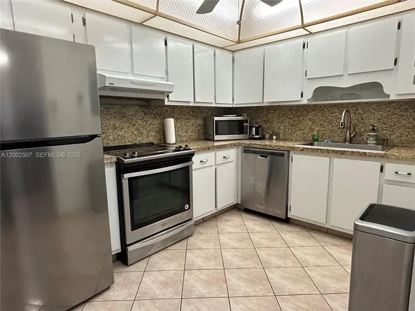 a kitchen with stainless steel appliances granite countertop a stove a refrigerator and a sink