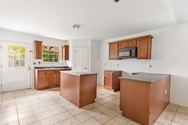 a view of a kitchen with stainless steel appliances granite countertop a sink and a refrigerator