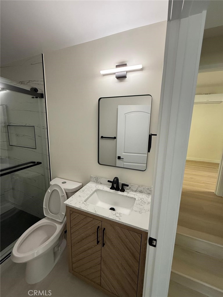 8601 Delco Avenue, Unit 1/4 Winnetka, CA 91306 - Photo 11 of 25 a bathroom with a toilet sink and mirror
