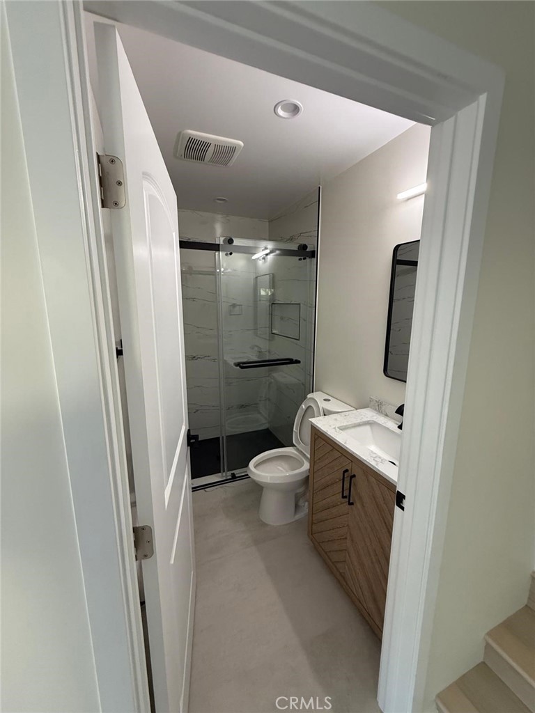 8601 Delco Avenue, Unit 1/4 Winnetka, CA 91306 - Photo 12 of 25 a bathroom with a toilet sink and a mirror