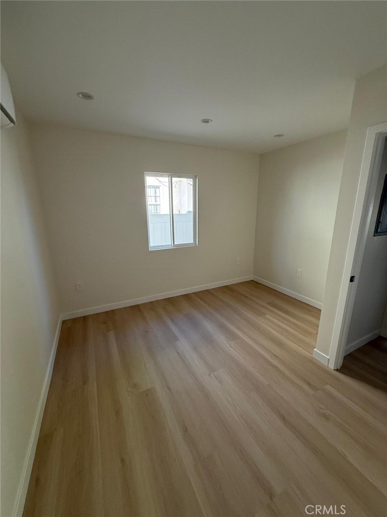 8601 Delco Avenue, Unit 1/4 Winnetka, CA 91306 - Photo 15 of 25 an empty room with wooden floor and windows