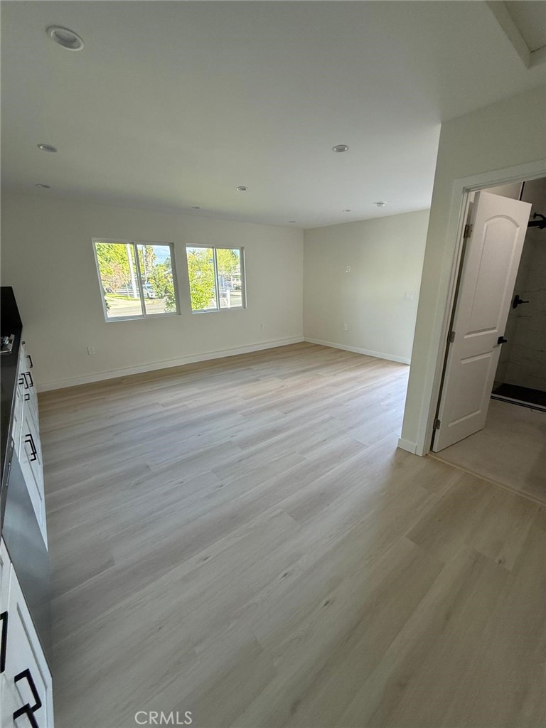 8601 Delco Avenue, Unit 1/4 Winnetka, CA 91306 - Photo 22 of 25 an empty room with wooden floor and windows