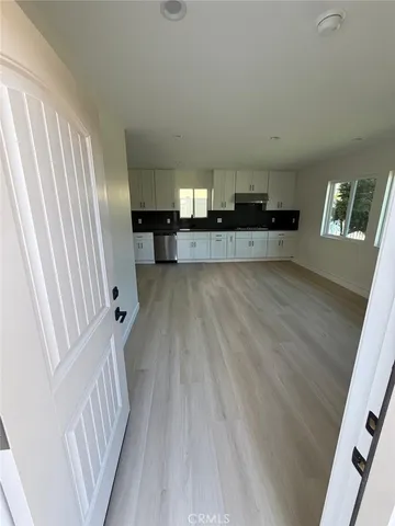 a view of an entryway with wooden floor and mirror