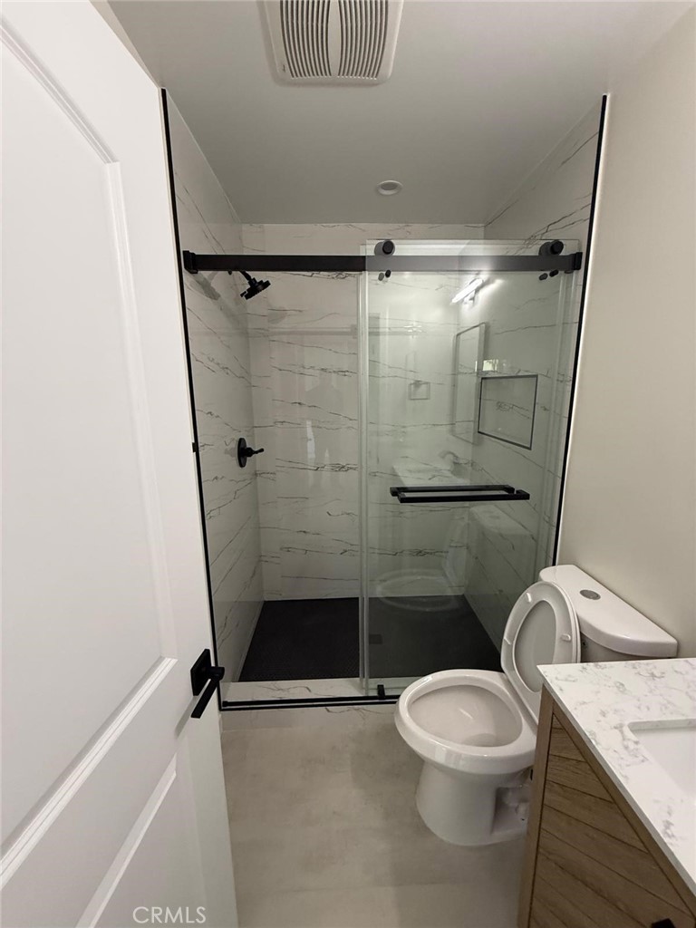 8601 Delco Avenue, Unit 1/4 Winnetka, CA 91306 - Photo 10 of 25 a bathroom with a granite countertop sink toilet and shower
