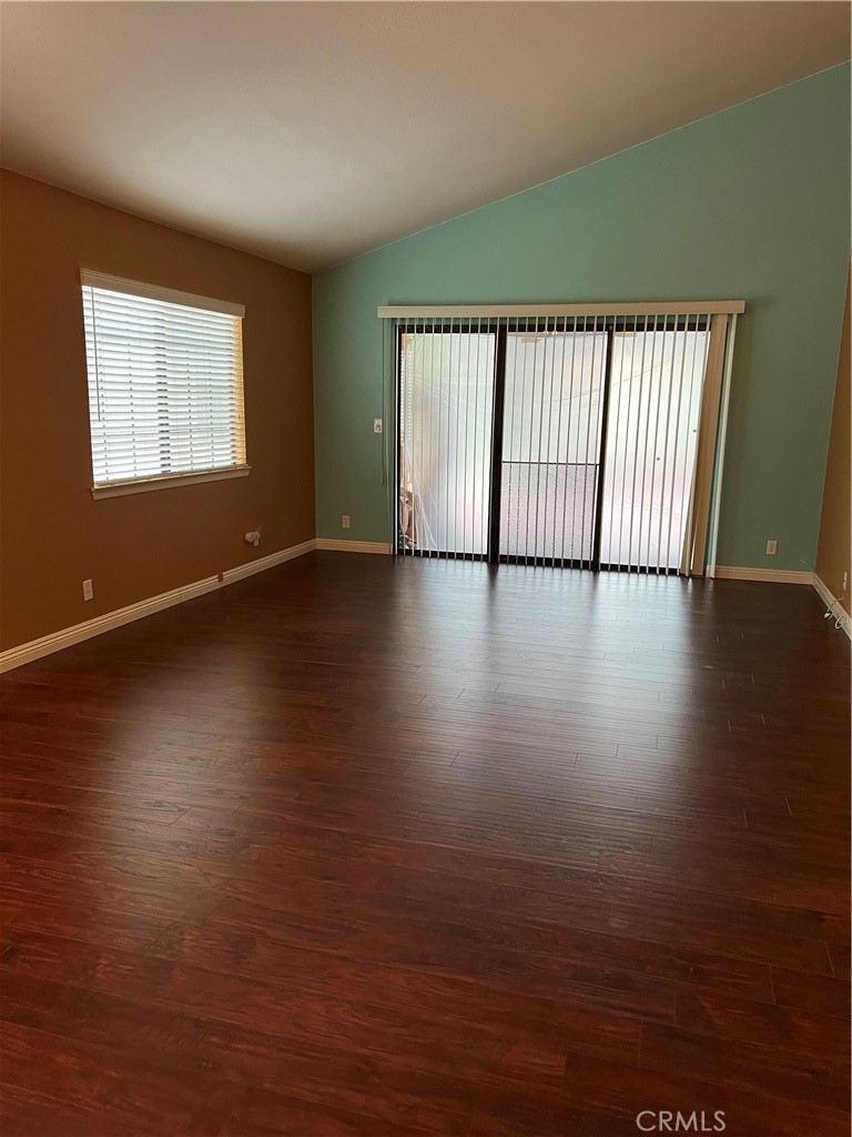 11675 Maple Street Apple Valley, CA 92308 - Photo 3 of 7 an empty room with wooden floor and windows