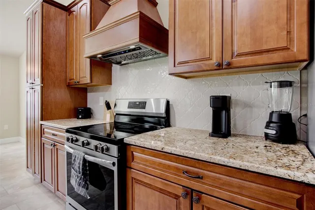 a kitchen with granite countertop a sink a stove and cabinets