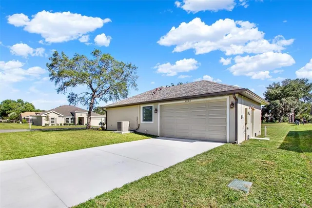 a front view of a house with a garden and trees