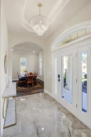 a view of a livingroom with furniture white walls and a chandelier