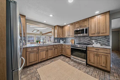a kitchen with granite countertop a stove top oven a sink and cabinets