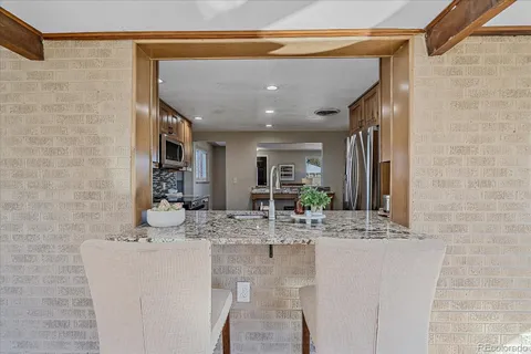 a bathroom with a granite countertop sink a mirror and shower