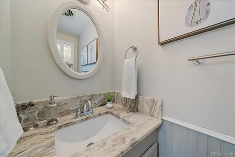 a bathroom with a granite countertop sink and a mirror