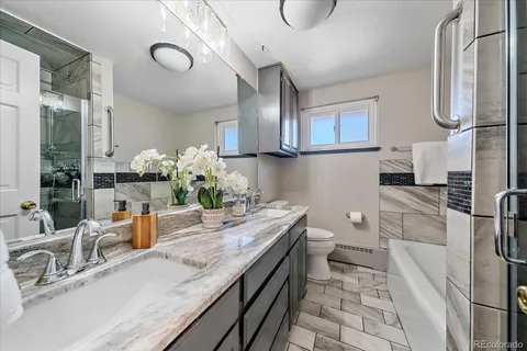 a bathroom with a granite countertop sink a toilet and mirror