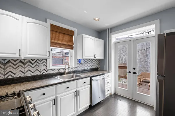 a kitchen with stainless steel appliances a sink stove and cabinets