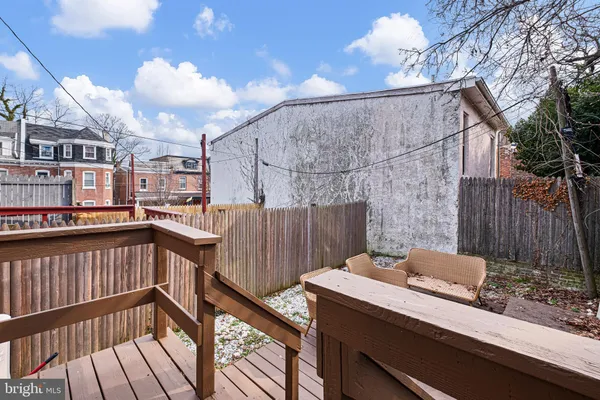 a view of a balcony with wooden floor and iron fence