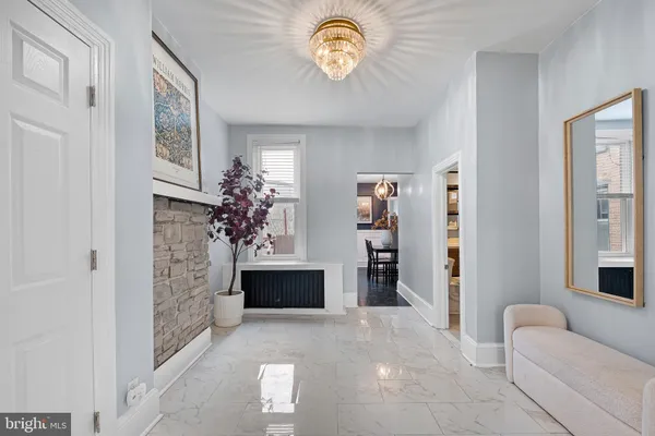 a living room with furniture a chandelier and a flat screen tv
