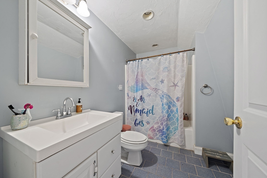 92 Spring Street Quincy, MA 02169 - Photo 21 of 34 a bathroom with a sink a toilet and shower curtain