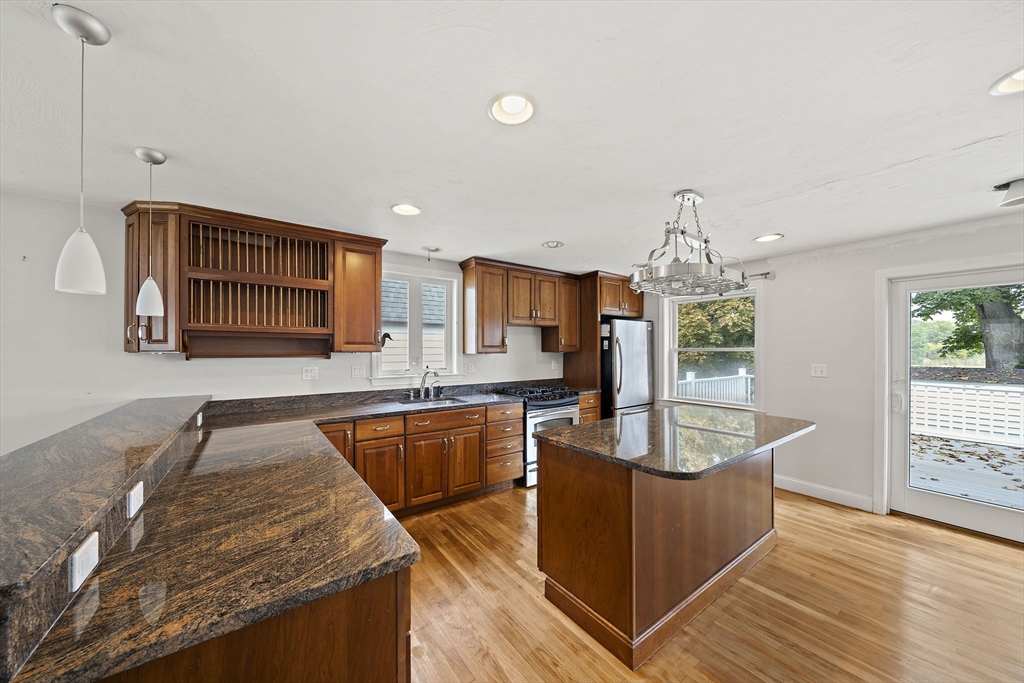 92 Spring Street Quincy, MA 02169 - Photo 4 of 34 a kitchen with stainless steel appliances granite countertop a sink a stove and a wooden floors