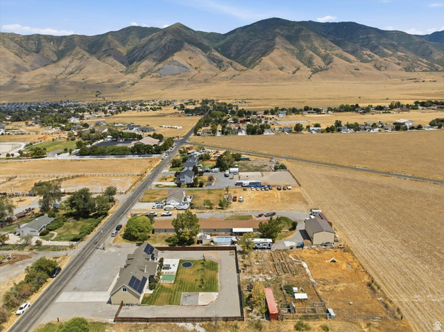 1232 Canyon Road Tooele, UT 84074 - Photo 6 of 54 Expansive property featuring a single-story residence with solar panels, a large gravel driveway, and a manicured lawn area with a trampoline