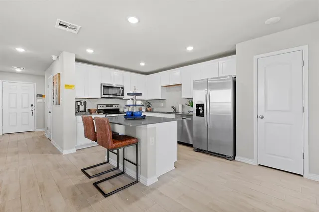a kitchen with stainless steel appliances kitchen island granite countertop a refrigerator and a stove top oven
