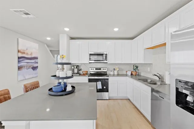 a kitchen with sink a stove and cabinets