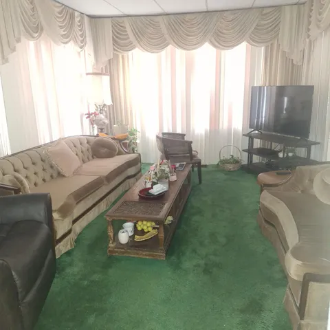 a living room with furniture and a floor to ceiling window