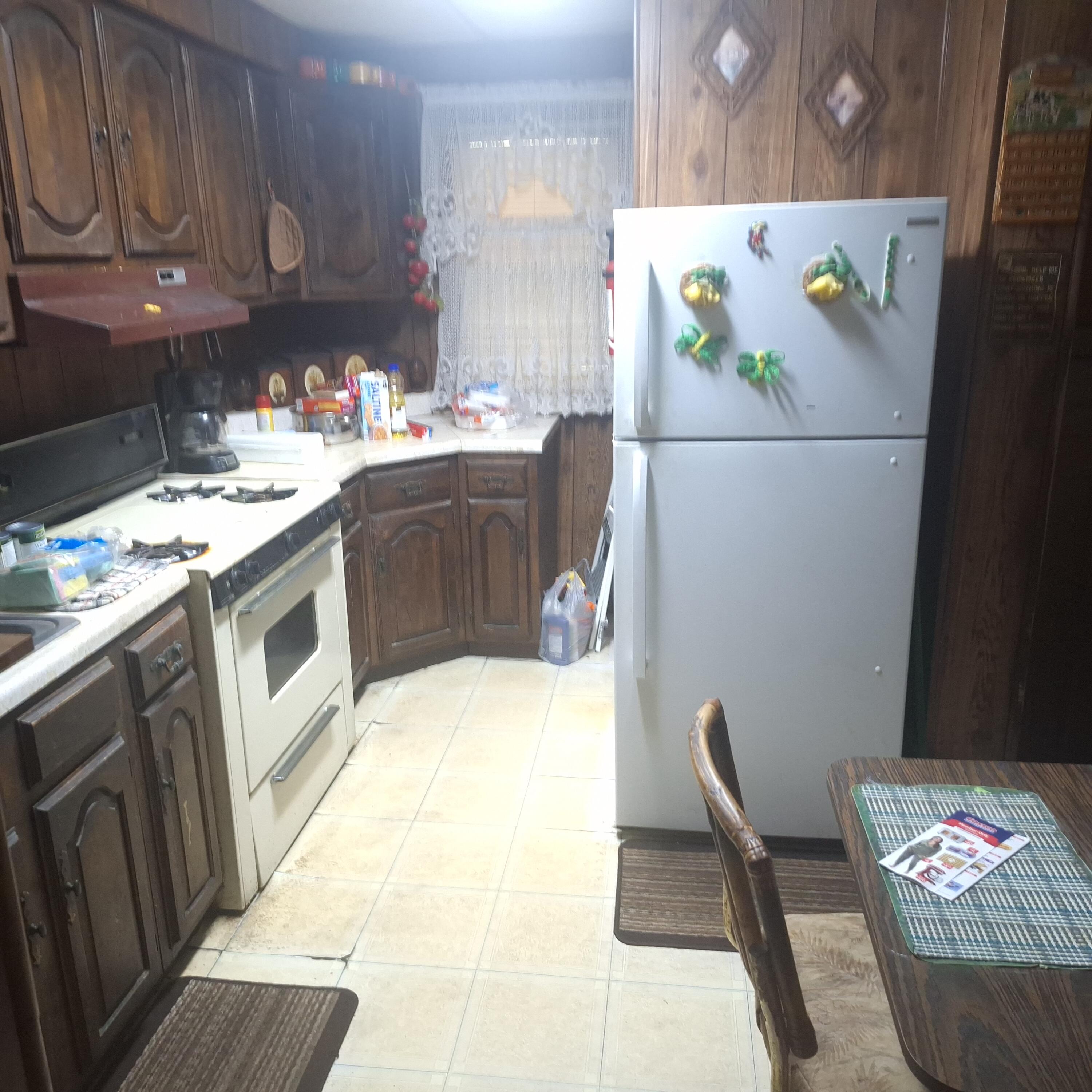 1165 Harrison Street Gary, IN 46407 - Photo 4 of 7 a kitchen with a sink a stove and a refrigerator