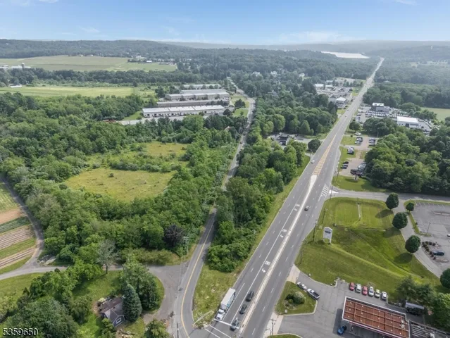 an aerial view of residential houses with outdoor space and trees