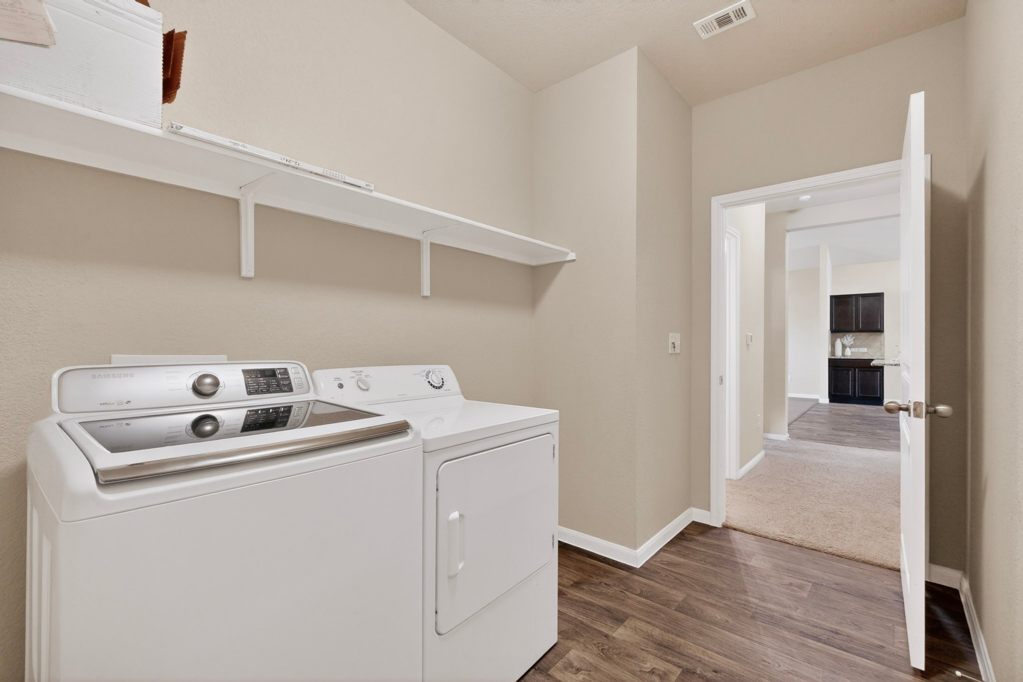5905 Diamondleaf Bend Austin, TX 78724 - Photo 21 of 38 Dedicated laundry area featuring wood-finish flooring, light tan wall color, and white shelving