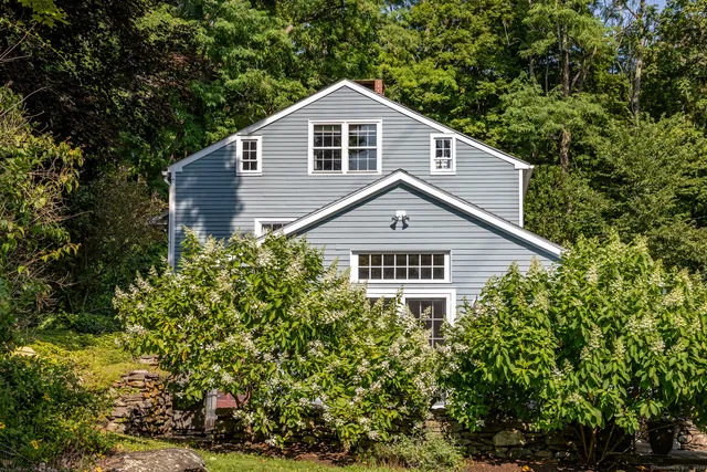 a view of a house with potted plants and a yard