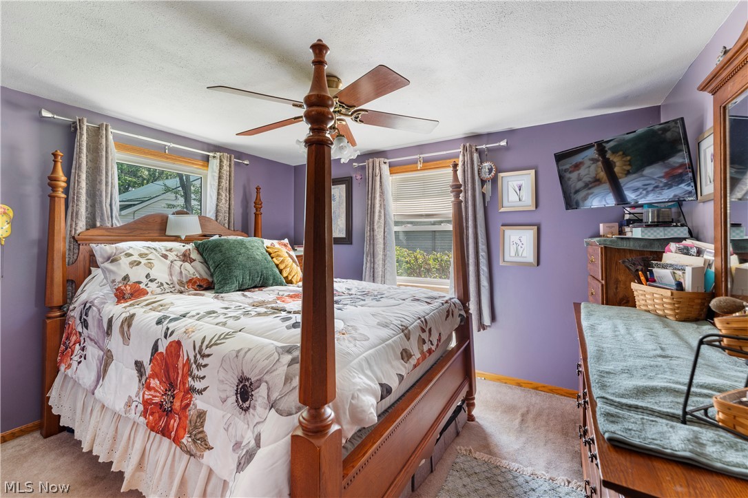 7000 Navarre Road Southwest Massillon, OH 44646 - Photo 15 of 22 This bedroom features a ceiling fan, windows with blinds and curtains, and soft carpet flooring