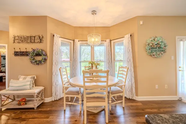 a living room with wooden floor and large windows