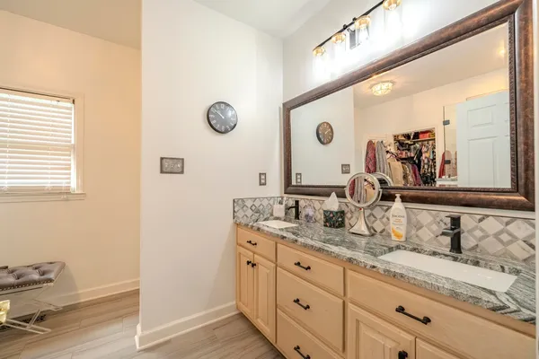 a bathroom with a granite countertop sink and a mirror