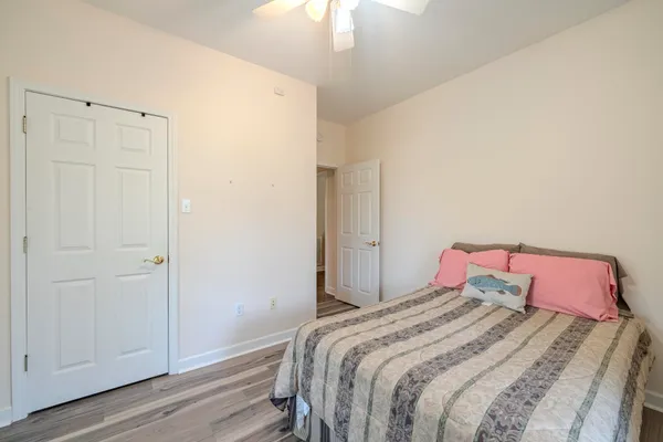 a bedroom with a bed and a chandelier fan